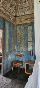 a bedroom with blue walls and a wooden table and a chair at Pondok Satu Hati Sidemen in Sidemen +56 photos