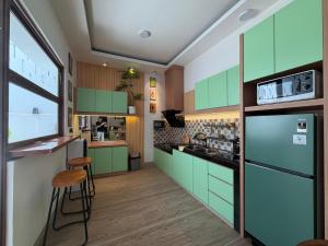 a kitchen with green cabinets and a counter at Pendo Mansion in Pulau Sembakau Kecil