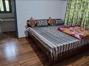 a bed with pillows on it in a room at Pathgami homestay kainchi dhaam in Bhowāli