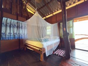 a bed in a room with a net at Ao Siri Beach Bungalow in Ko Jum