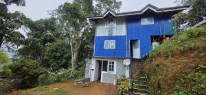 a blue house on the side of a hill at Kithul Cottage 2 in Watagoda