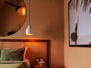a bedroom with a bed and a mirror and a lamp at Motel LOVE SONG Canggu in Canggu