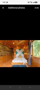a bedroom with a bed in a wooden room at Blissful Lodge in Banjār