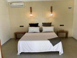 a bedroom with a large white bed with two pillows at Casa ysatis in Lazi