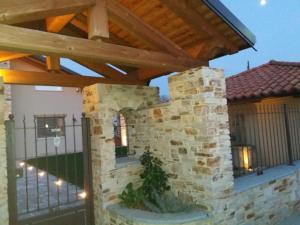 una chimenea de piedra al aire libre bajo una pérgola de madera en La Casa Di Kiki, en Cuneo