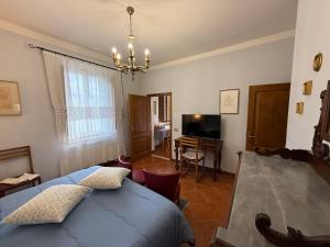 a bedroom with a bed and a desk and a television at B&B Il Pettirosso di Siena in Siena