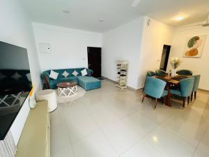 a living room with a blue couch and a table at Santorini VIP in Negombo