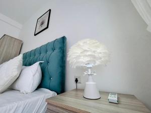 a bedroom with a blue headboard and a table with aumedumedumed flower at Santorini VIP in Negombo