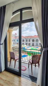 a balcony with two chairs and a view of a pool at The Star hotel DTH3-31 in Phú Quốc