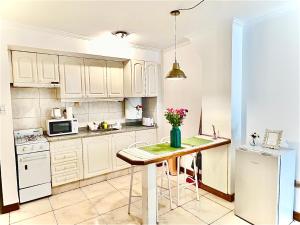 a kitchen with white cabinets and a table with flowers on it at MENDOZA Suites 1 -con estacionamiento opcional- in Mendoza