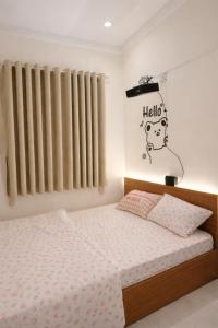 a bedroom with a bed with a hello sign on the wall at The Tiny Cineroom & Homestay in Buon Ma Thuot +24 photos