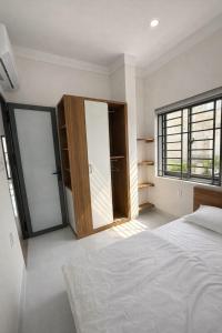 a bedroom with a bed and a large window at The Tiny Cineroom & Homestay in Buon Ma Thuot