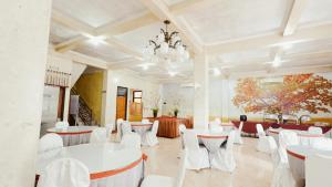 a large room with white tables and white chairs at Tripletree Sinergi Hotel Tretes in Pasuruan