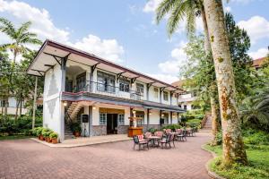 a building with a patio with tables and chairs at Tripletree Sinergi Hotel Tretes in Pasuruan