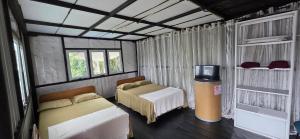 a bedroom with two beds and a tv in it at Kithul Cottage 2 in Watagoda