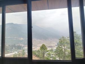 a window with a view of a mountain view at Pines Dirang Homestay in Chug