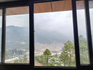 a view of a mountain from a window at Pines Dirang Homestay in Chug