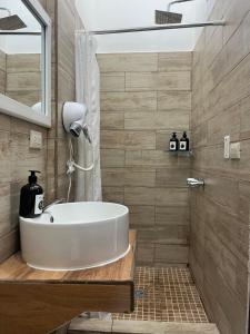 a bathroom with a white tub and a shower at 8 habitaciones para 16 personas in Flores +71 photos