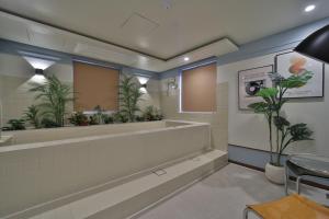 a bathroom with a large mirror and plants at 그랑메종 바오밥 호텔 in Gwangju