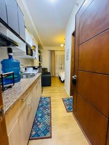 a kitchen with a sink and a large wooden door at Chic and Affordable Studio in Davao City