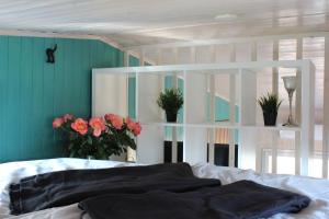 a bedroom with a bed with flowers and a white shelf at KE-Tiny Siedlung Haus Charlie in Oerlenbach