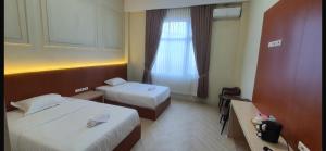 a hotel room with two beds and a window at Mabit Hotel Syariah in Takengon +21 photos