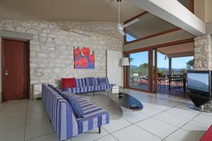 ein Wohnzimmer mit 2 Sofas und einem TV in der Unterkunft Villa Elena in Manerba del Garda