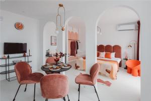 a living room with orange chairs and a bedroom at Pine & Cedar Suites – Hua Xiao Ye in Shanghai