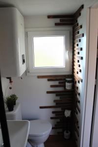 a bathroom with a white toilet and a window at KE-Tiny Siedlung Haus Charlie in Oerlenbach +27 photos
