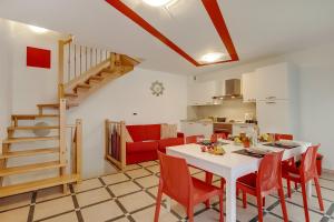 a kitchen and dining room with a white table and red chairs at Clementines 50 Meters From Sea - Happy Rentals in Roquebrune-Cap-Martin
