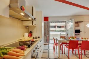 a kitchen with red chairs and a table with food on it at Clementines 50 Meters From Sea - Happy Rentals in Roquebrune-Cap-Martin