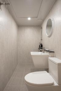 a bathroom with a white toilet and a sink at Parvus Sella Seongsu in Seoul