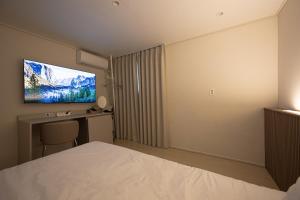 a hotel room with a bed and a flat screen tv at Parvus Sella Seongsu in Seoul
