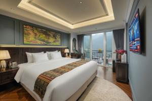 a bedroom with a large white bed and a balcony at Sapa Horizon Hotel & Skybar in Sapa +66 photos