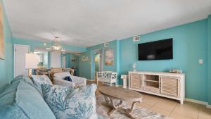 a living room with a couch and a tv on a wall at Beachfront Bliss in Gulf Shores