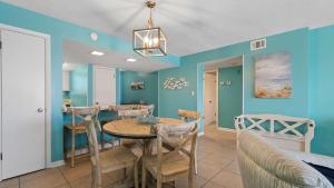a dining room with blue walls and a table and chairs at Beachfront Bliss in Gulf Shores