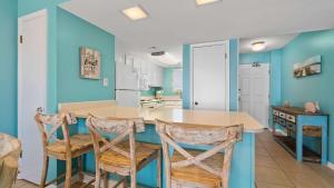 a kitchen with blue walls and a table and chairs at Beachfront Bliss in Gulf Shores +23 photos
