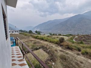 a balcony of a house with mountains in the background at Hotel Royal galaxy in Dharāsu