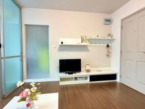 a living room with a flat screen tv on a white wall at Calm Home in Phuket +4 photos
