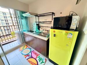 a yellow refrigerator in a kitchen with a sink at Calm Home in Phuket