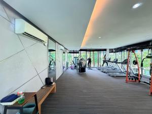a gym with benches and treadmills and people on bikes at Calm Home in Phuket