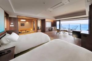 a hotel room with two beds and a view of the ocean at 游水亭いさごや in Tsuruoka