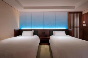 two beds sitting next to each other in a room at 游水亭いさごや in Tsuruoka