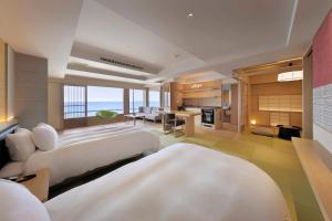a living room with two beds and a kitchen at 游水亭いさごや in Tsuruoka