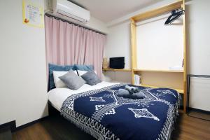 a bedroom with a bed with a teddy bear on it at Nogata House in Tokyo
