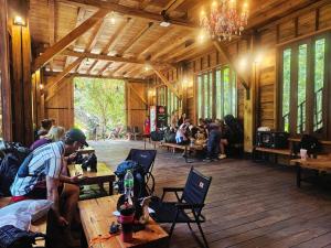 a group of people sitting at tables in a building at คีรีเขาสกริเวอร์ Keereekhaosokriver in Khao Sok National Park