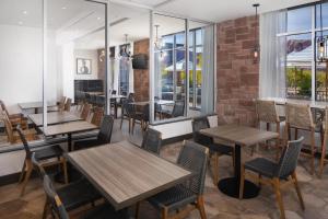 a restaurant with wooden tables and chairs and windows at Hyatt Place Moab in Moab