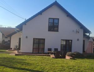 a white house with a lawn in front of it at Tisovecký apartmán in Tisovec