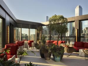 a rooftop patio with furniture and plants on a building at Hannah St Hotel Melbourne in Melbourne