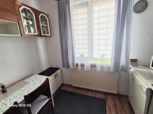 a small kitchen with a window and a table at ,,Arts Home,, ,ZAPRASZAM ,blisko las,dużo przyrody, blisko centrum kardiologii,centrum szkoleniowe,trasa na Lublin,Ukrainę,mieszkanie przestronne,czyste,spokojna okolica,blisko Aldi,Lidl,Żabka,Rossmann,pkp, ztm in Warsaw